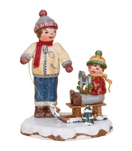 Village de Noël miniature, garçon et petit frère sur luge