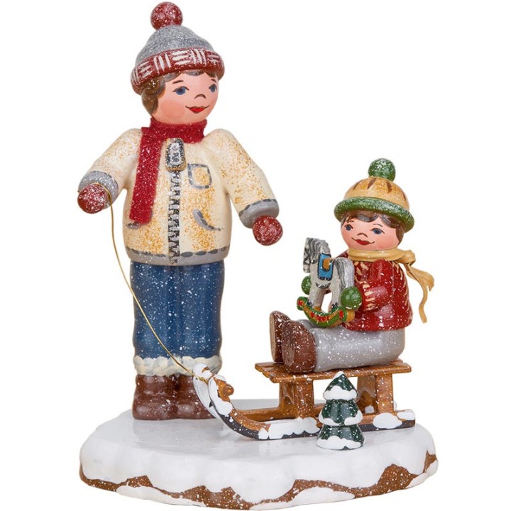 Village de Noël miniature, garçon et petit frère sur luge