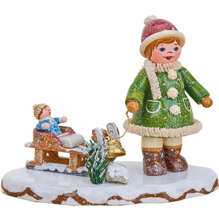 Village de Noël miniature, fillette avec petit frère sur luge
